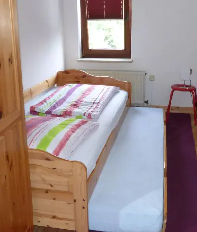 Ferienhaus Adendorf: Schlafzimmer 3 mit zur Hälfte ausgezogenem zweitem Bett. 0012e.webp